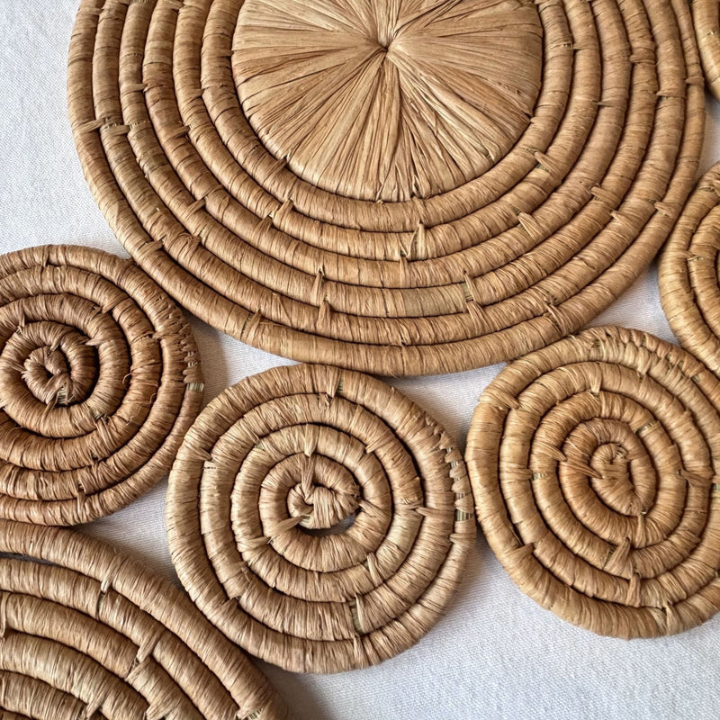 Closeup of raffia wall art / table runner with circular coiled wave pattern.  Handmade, fair trade certified, wildlife friendly, naturally dyed, sustainably sourced raw materials.  Made in Madagascar.
