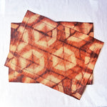 Ethically made fair trade handmade Madagascar raffia placemats, shibori dyed hexagon pattern, warm earthy rust coral red and tan linen color earthy colors home decor modern rustic, 14"x19"