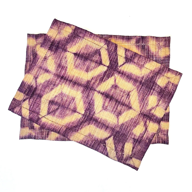 Shibori-Dyed Raffia Placemats, handmade, fair trade, boysenberry fuschia purple with light tan in an elegant hexagon pattern. Rectangular shape. Set of two.
