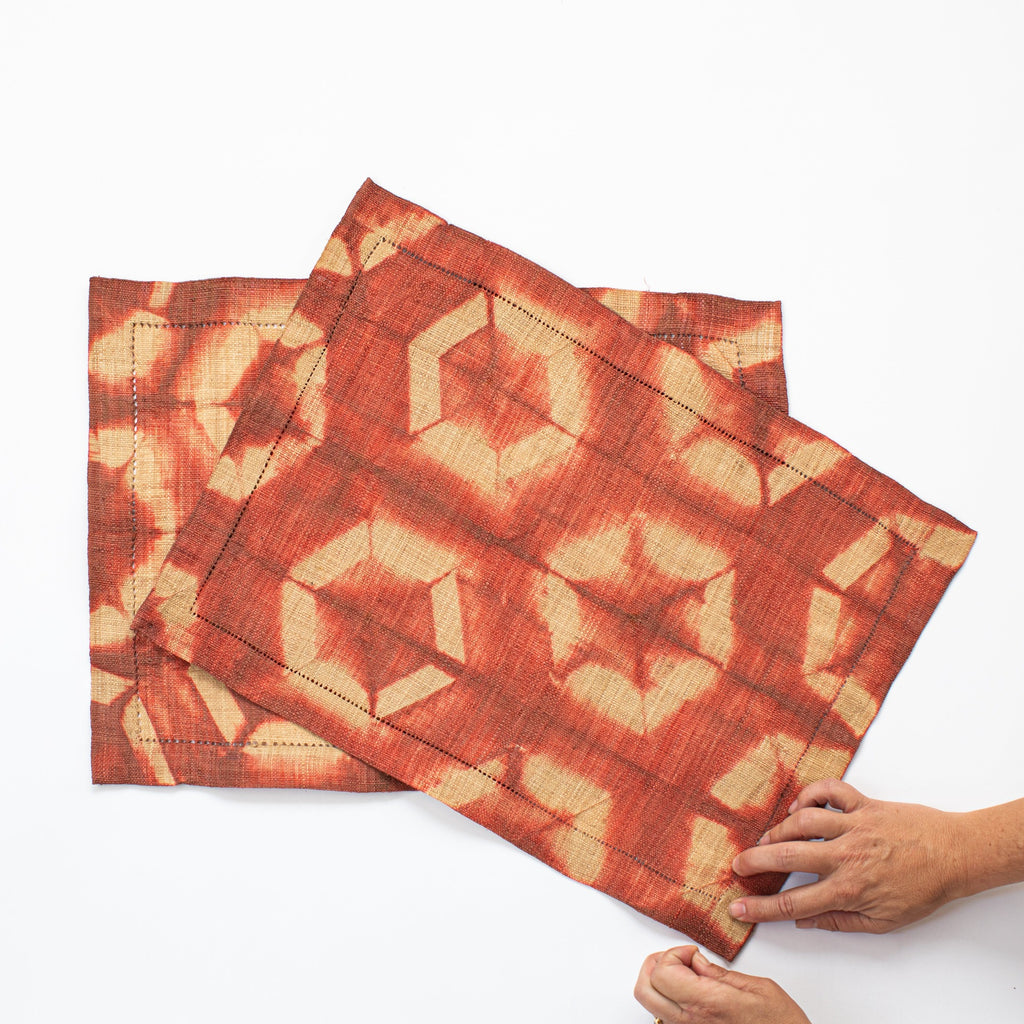 Ethically sourced fair trade rainforest friendly Madagascar raffia rectangular placemats (set of two) terra cotta rusty orange pumpkin and tan colored batik dyed table linens home decor modern rustic. Thanksgiving color placemats.